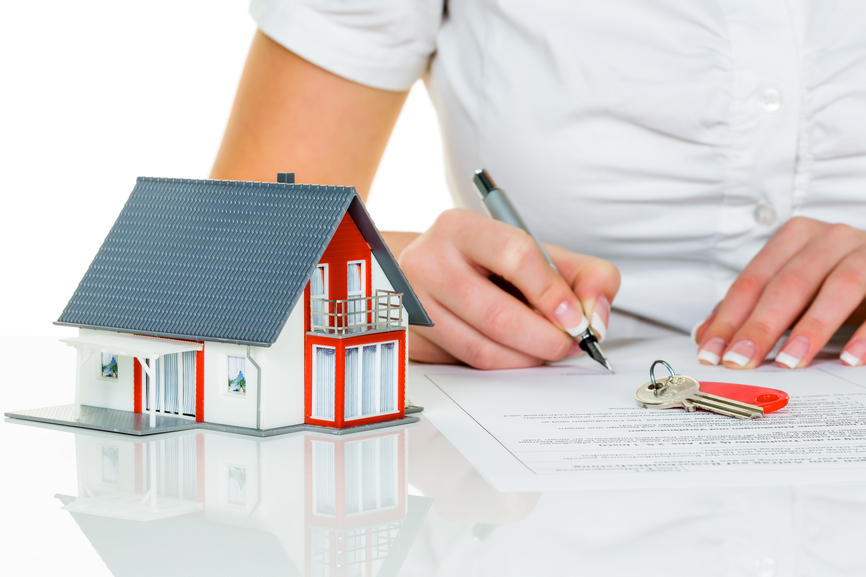 a woman signs a purchase contract for a home with a real estate agent.